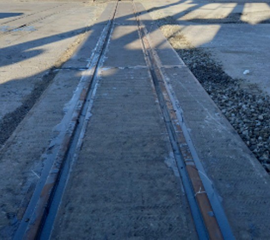 Vista do trilho ferroviário com solo pavimentado, refletindo a infraestrutura utilizada pela Rumo para transporte ferroviário.