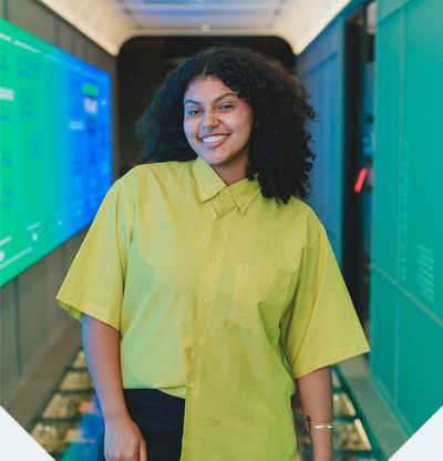 Mulher sorrindo e ao fundo um computador